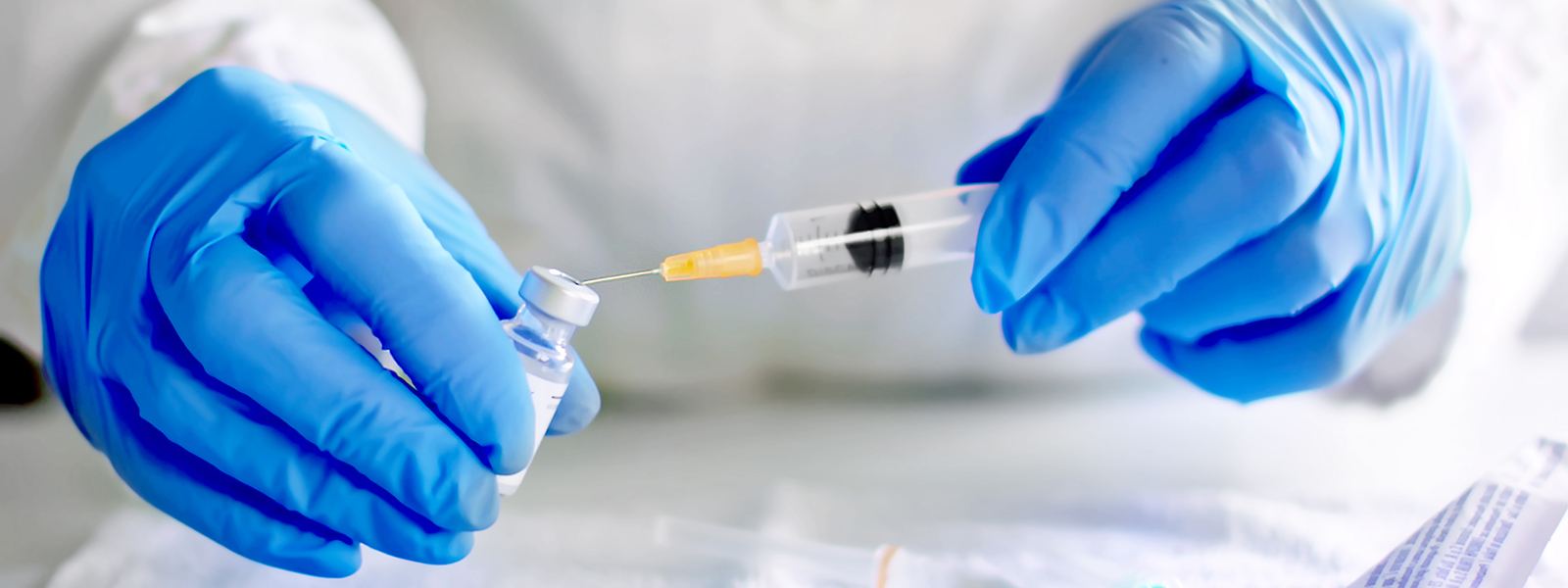 Pair of gloved hands holding a needle