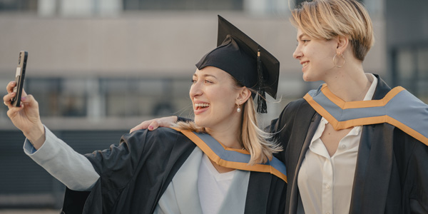 Two graduates taking a picture of themselves on a mobile phone