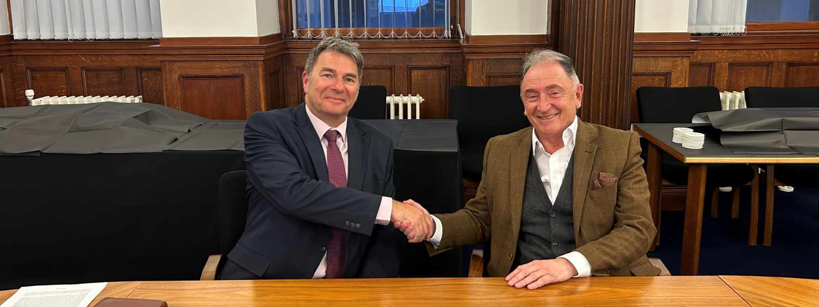 NHS 24 Chief Executive Jim Miller with Professor Sir Jim McDonald, Principal & Vice-Chancellor of the University of Strathclyde shaking hands.
