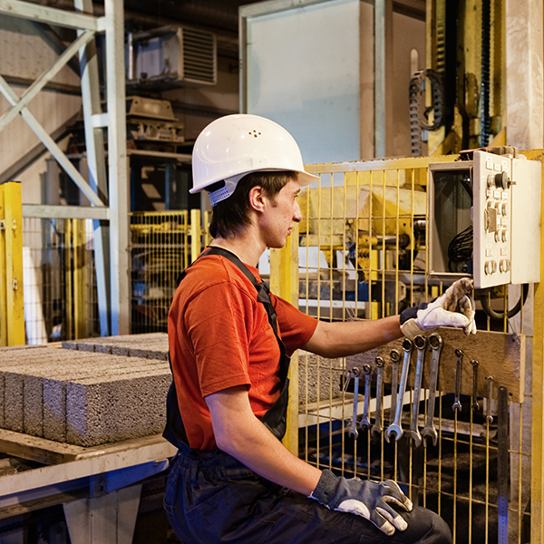 Male in hard hat checking machinery