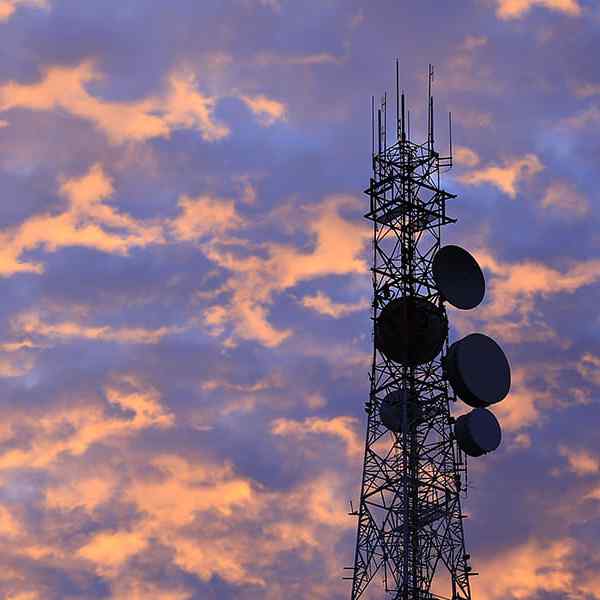 Telecommunication tower Antenna and satellite dish at sunset sky background