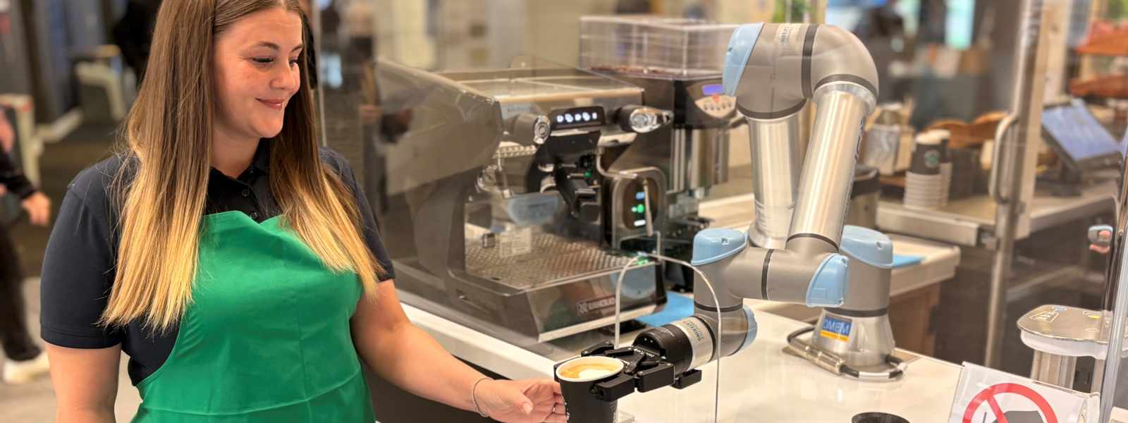 Food and Beverage assistant Donna Bowers with the cobot