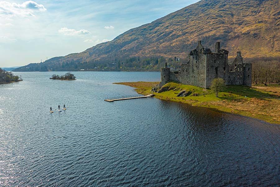 Paddleboarders on the loch at Kilchurn Castle.