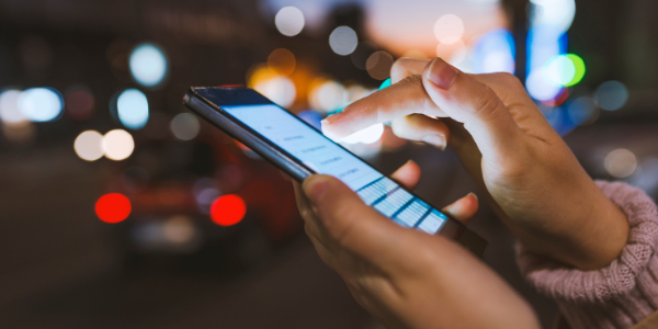 Close-up of a woman's hand scrolling on a social media screen on a mobile phone